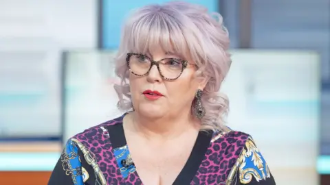Baroness Helen Newlove, a woman with dyed pink and white hair, wearing a colourful dress and long earrings, appears on Good Morning Britain TV show in February 2020