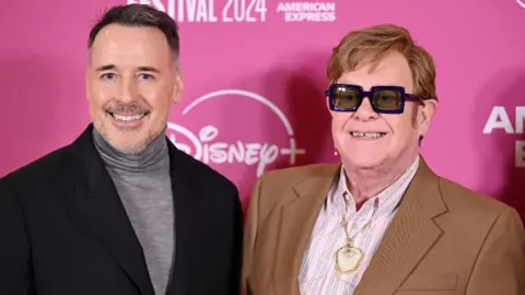 Getty Images David Furnish e Elton John comparecem ao "Elton John: Nunca é tarde demais" Gala principal durante o 68º BFI London Film Festival no Royal Festival Hall em 10 de outubro de 2024 em Londres, Inglaterra