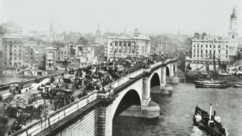 The London Archives, City of London Une photographie en noir et blanc de 1895 montrant la circulation hippomobile sur le pont de Londres original