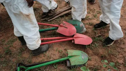 AFP via Getty Images Shovels are on the ground at the mass-grave site in Shakahola, outside the coastal town of Malindi, on April 25, 2023