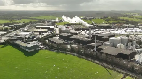 An aerial shot of Granville Industrial Estate showing a range of industrial buildings and a chimney with smoke or steam coming out of it.