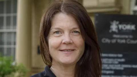 City of York Council Woman with shoulder length dark hair looks at camera