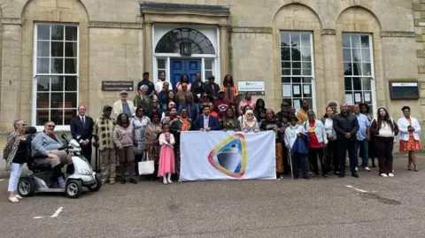 Charlotte Vowden/BBC A group of people marking Windrush Day in Wellingborough