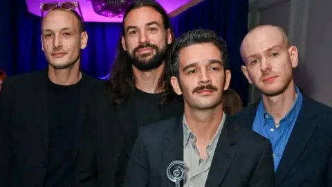 Getty Images George Daniel, Ross MacDonald, Matthew Healy and Adam Hann of The 1975, winner of Best Group Award, attend the Nordoff and Robbins O2 Silver Clef Awards 2024 at The Grosvenor House Hotel on July 5, 2024 in London, England.