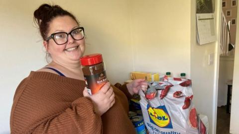 Trudi Price holding a jar of coffee next to a Lidl carrier bag