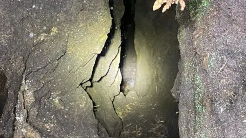 Scarborough and Ryedale Mountain Rescue Team An image looking down through a cave, with rocky walls. 