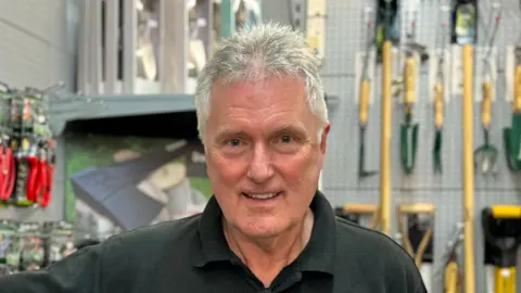 Zoie O'Brien/BBC A head and shoulders image of a man wearing dark polo shirt and looking directly into the camera.