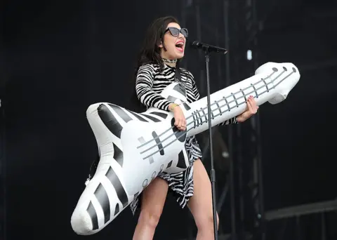 Getty Images Charli XCX plays an inflatable guitar