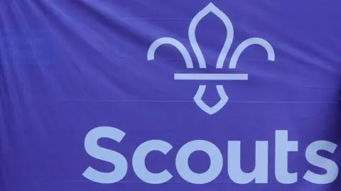 The Scouts logo is printed in white on a purple background on a large flag