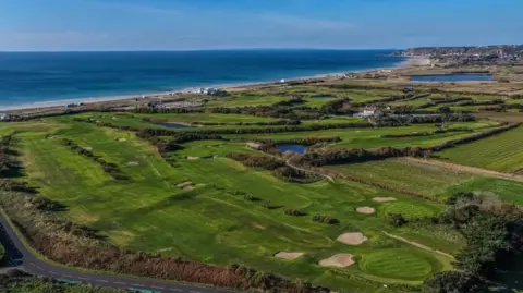 Craig Robinson/ Savills An aerial image of the golf course with the sea visible in the background. 