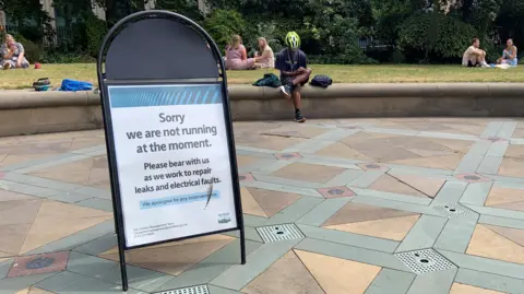 A sign in a park reading 'Sorry we are not running at the moment'.