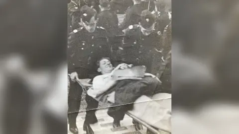 Supplied Black and white image of Lt Willis on a stretcher