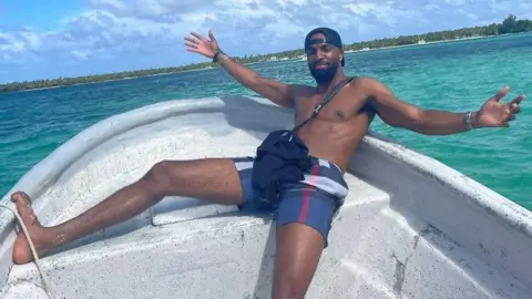 Nottinghamshire Police James is posing for the camera in a small boat on the sea