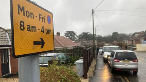 A road sign restricting parking between 8am and 4pm