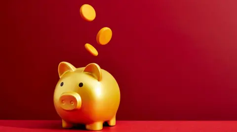 Getty Images Coins dropping into a piggy bank - stock photo