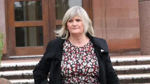 Central Scotland News Agency A woman wearing a red, white and black dress, and a black coat  leaves a court building