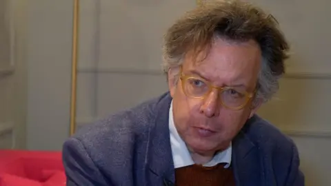 Richard Blakeway, a man with greying hair, glasses and wearing a dark-coloured jacket over a shirt with a white collar and dark-coloured jumper