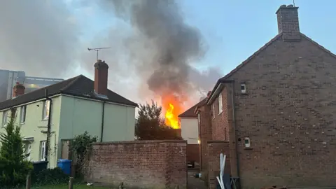 Isaac Chenery/BBC Flames can be seen coming from a house in Portman Road