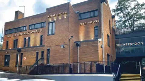 University of Surrey A brown brick building. It says Wetherspoon on the outside.