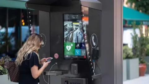 A CGI image of a woman using one of the phone charging points on the proposed digital help hub.