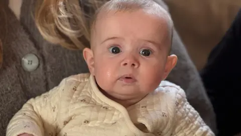 A baby in a cream jacket