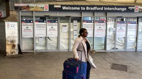A woman walks past the closed entrance to Bradford Interchange in Bradford