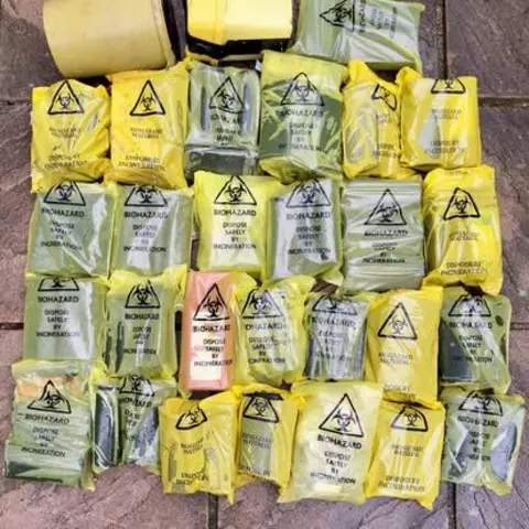 Clean Our Patch CIC Yellow sharps bags with the word biohazard line the floor. Inside each one is a sharps box.