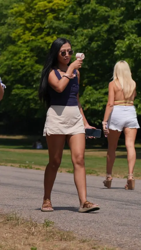 People on The Long Walk in Windsor, Berkshire. Extreme heat across the UK is causing early harvests and forcing local authorities to introduce hosepipe bans as forecasters confirm that last month was western Europe's hottest June on record.