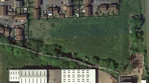 Aerial view of green next to housing estate