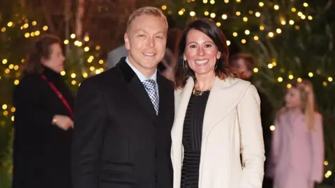 James Manning/PA Wire Sir Chris Hoy and his wife Sarra smile as they arrive for the annual service