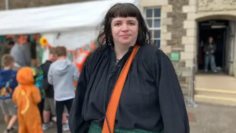 Organiser Amy Potter wears a black blouse with an orange strap.