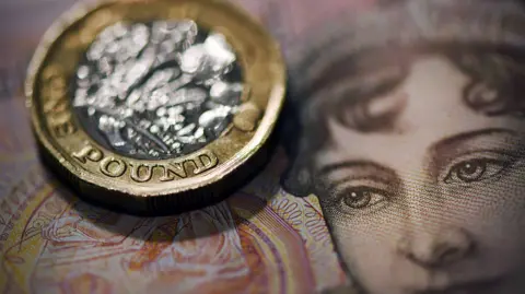BBC Close-up shot of a pound coin and a note.