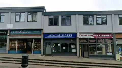 Google maps street view of Bengal Balti and the neighbouring shops. The storefront is royal blue.