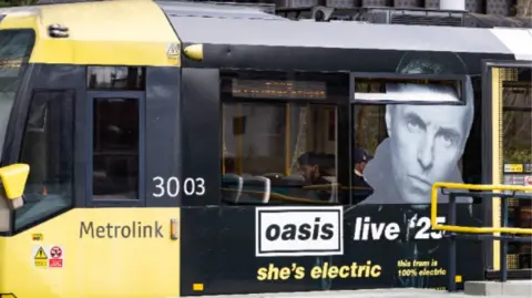 TfGM A yellow Manchester tram with a photo of Liam Gallagher underneath an Oasis sign