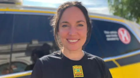 Dr Poppy Elmhirst stood in front of the response car, looking at the camera