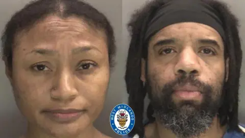 Tamara and Damion Thomas pictured in a mugshot with no expression on their faces. Tamara has he hair slicked back behind her while Damion has thick shoulder length dreadlocks and wears a thick black headband across his forehead.
