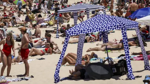 Getty Images Beachgoers are seen on the sand on Christmas Day at Bondi Beach in Sydney on December 25, 2024.