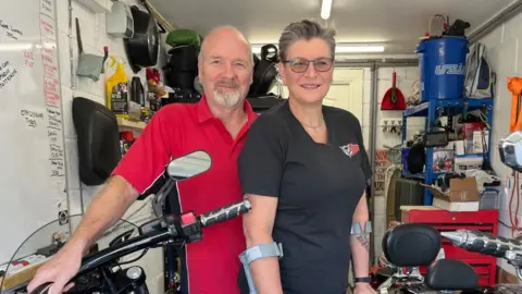 Supplied A view of Janet Crook-Moore stood on the right with the help of crutches in the garage with her husband Roger Moore.