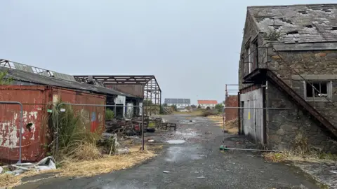 Leale's Yard - A derelict site with gates, and grey granite buildings. 