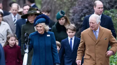 Getty Images Several members of the Royal Family in winter coats walk together to attend a church service. Queen Camilla and King Charles III lead the family.