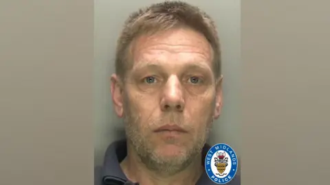 Police mugshot of the defendant, with short fair hair and stubble. He is wearing a dark polo shirt and standing in front of a plain grey background.  