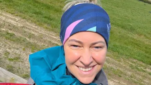 Family handout Justine is standing in a field and is smiling at a the camera in this selfie. 