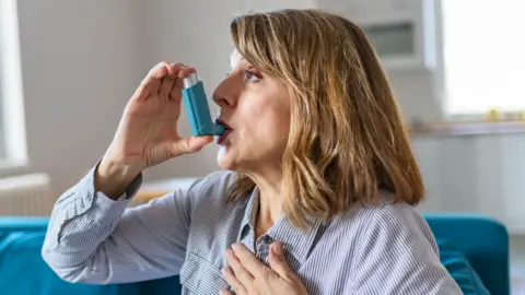 Getty Images woman using blue inhaler