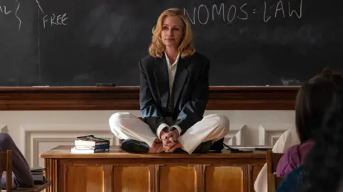 Sony Pictures Classics Julia Robers in After The Hunt, sitting on a desk at the front of a classroom