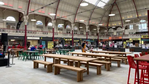 Rows of seating and tables can be seen inside Derby Market Hall