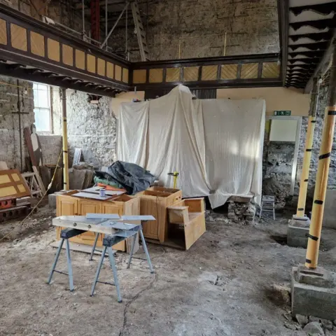 Weardale Museum The chapel is a working site with the fixtures stripped out and a work table in the middle.