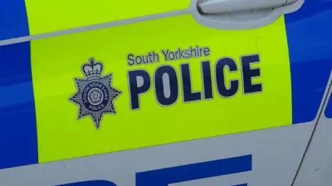 A picture of a door of police car with the words South Yorkshire Polic written on. 