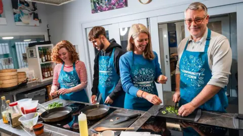 Govia Thameslink Railway Two women and two men cooking using pans, saucepans and a chopping board.