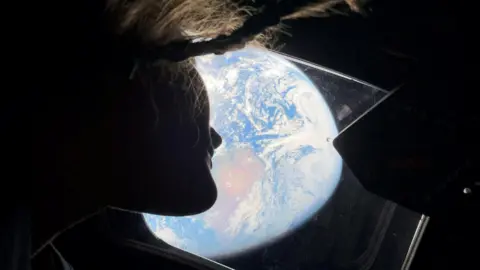 Reuters NASA astronaut and Artemis II mission specialist Christina Koch peers out of one of the Orion spacecraft's main cabin windows, looking back at Earth.