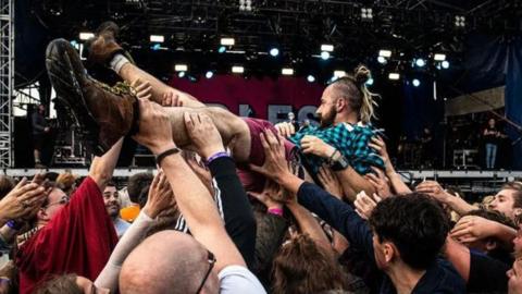 Idles singer being held by fans